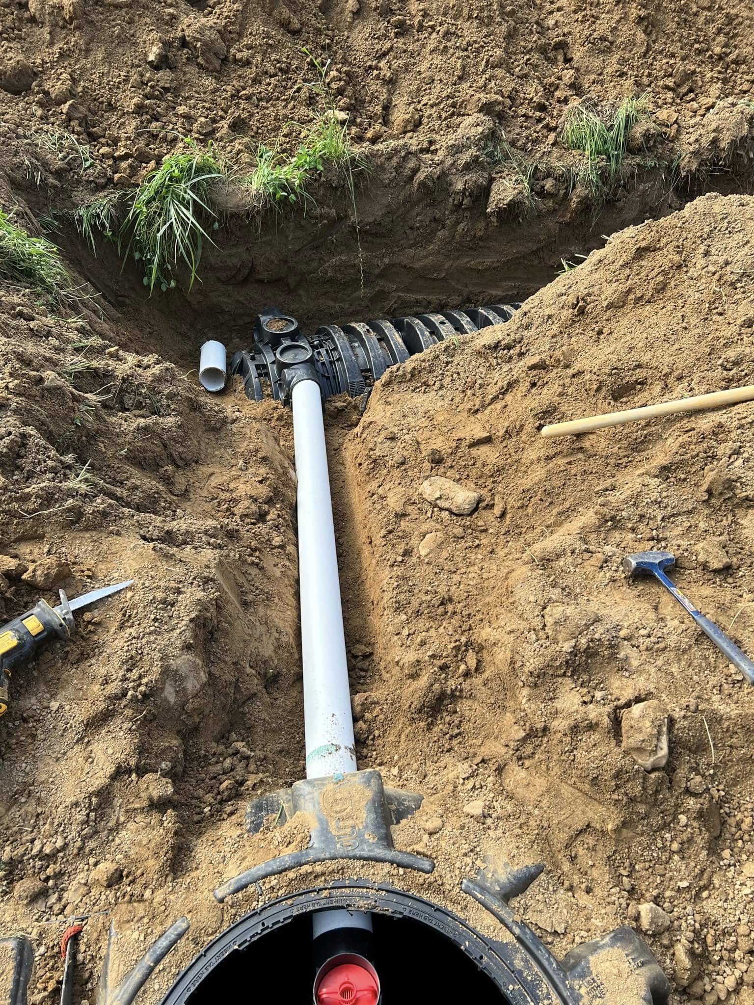 Drainage and septic pipe connections set in a trench near Burnsville, NC